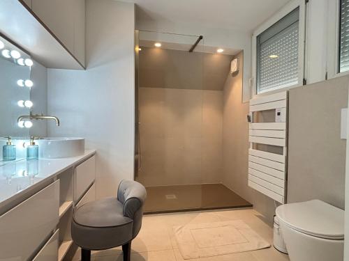 La salle de bains est pourvue de toilettes, d'un lavabo et d'une chaise. dans l'établissement Appartement spacieux 3 chambres face plage, 6 personnes - FR-1-197-628, à Les Sables-dʼOlonne