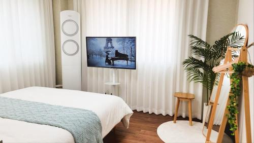 a bedroom with a bed and a tv on the wall at MISO Stay in Seoul