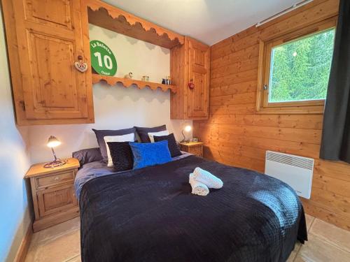 une chambre avec un grand lit avec des oreillers bleus dans l'établissement Appartement 3 pièces pour 4 personnes à Méribel, proche des pistes, terrasse, parking, WIFI - FR-1-411-986, à Les Allues