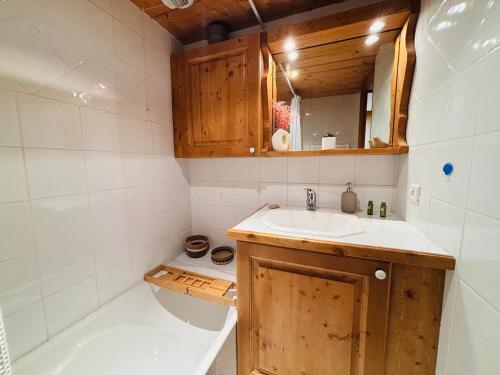 La petite salle de bains est pourvue d'un lavabo et d'une baignoire. dans l'établissement Appartement 3 pièces pour 4 personnes à Méribel, proche des pistes, terrasse, parking, WIFI - FR-1-411-986, à Les Allues