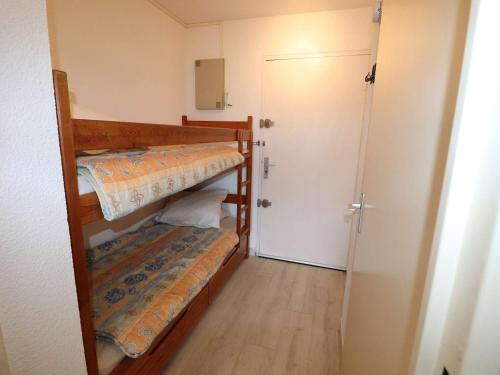Cette petite chambre comprend 2 lits superposés et une porte. dans l'établissement Studio cabine pour 4 pers avec parking près de la mer - FR-1-307-288, au Grau-du-Roi