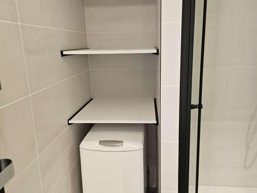 une salle de bain avec des toilettes avec une étagère au-dessus dans l'établissement Appartement 2 pièces, terrasse vue port, parking privé, clim, animaux admis - FR-1-250-313, au Grau-du-Roi