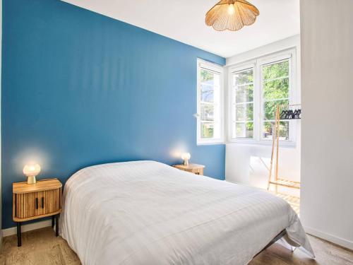 - une chambre bleue avec un lit et 2 tables de chevet dans l'établissement Appartement charmant avec jardinet, proche plage, 2 chambres - FR-1-788-79, à Merville-Franceville-Plage