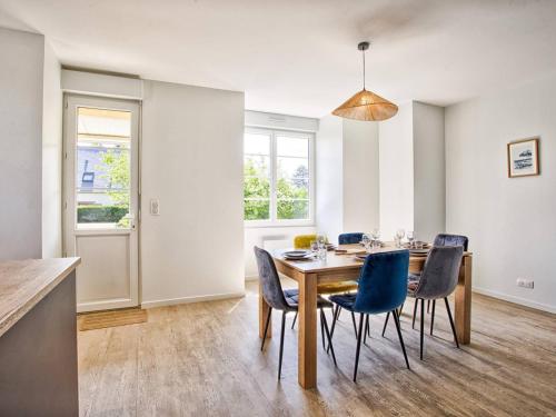 une salle à manger avec une table et des chaises bleues dans l'établissement Appartement charmant avec jardinet, proche plage, 2 chambres - FR-1-788-79, à Merville-Franceville-Plage