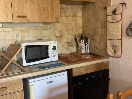 une cuisine avec un micro-ondes et un plan de travail dans l'établissement T2 à Hyères avec Parking, 4 Personnes - FR-1-335-207, à Hyères