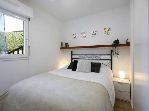 une chambre blanche avec un lit et une fenêtre dans l'établissement Appartement Hendaye avec piscine et parking - FR-1-2-443, à Hendaye