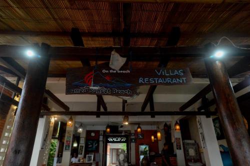 a sign hanging from the ceiling of a restaurant at Amed Sunset Beach in Amed