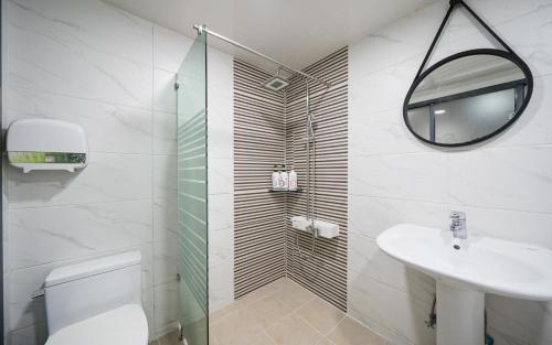 a bathroom with a toilet and a sink and a mirror at Daegu Suseong DRAMA in Daegu