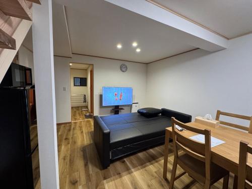 a living room with a couch and a dining room table at 熱海網代くす亭 in Atami