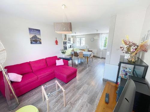 - un salon avec un canapé rouge et une salle à manger dans l'établissement Appartement cosy à 200m de la mer, 2 chambres, centre-ville de St Pair-sur-Mer, parking inclus - FR-1-361-543, à Saint-Pair-sur-Mer
