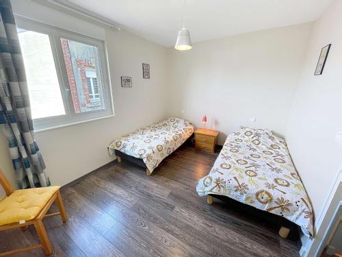a bedroom with two beds and a window at Appartement cosy à 200m de la mer, 2 chambres, centre-ville de St Pair-sur-Mer, parking inclus - FR-1-361-543 in Saint-Pair-sur-Mer
