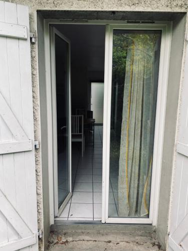 une porte ouverte d'une maison avec une terrasse dans l'établissement Appartement Cosy Pau avec Jardin, à Pau