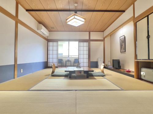 a large room with a table and chairs at Yuhigauraonsen ShizukaHanaogi in Kyotango