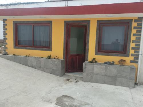 a yellow building with red doors and windows at Hermosa casita en el centro de Tlatlauquitepec Pueblo Magico in Tlatlauquitepec