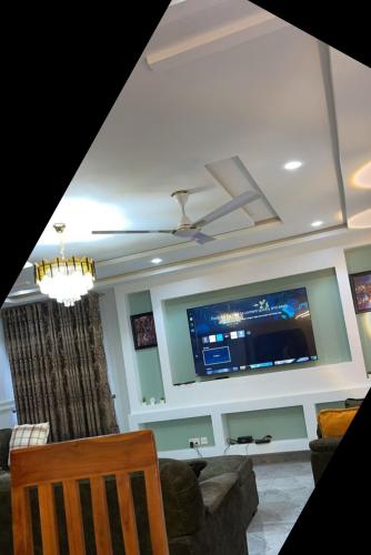 a living room with a flat screen tv on a wall at Arek Condos Accra in Sotuom