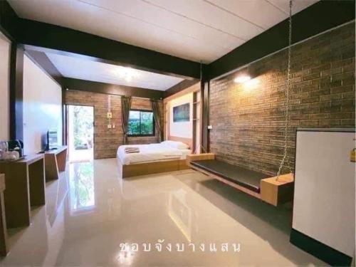 a bedroom with a bed and a brick wall at กัลยา รีสอร์ท in Ban Bang Saen (1)
