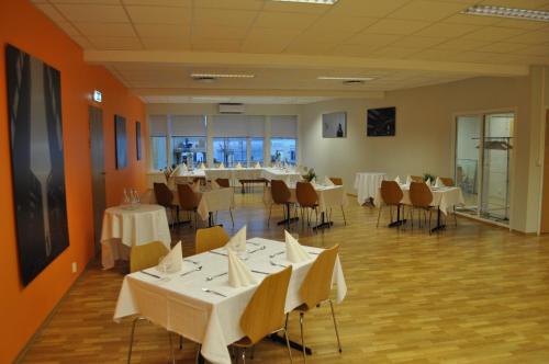 uma sala de jantar com mesas e cadeiras brancas em Suldal Hotell em Sand