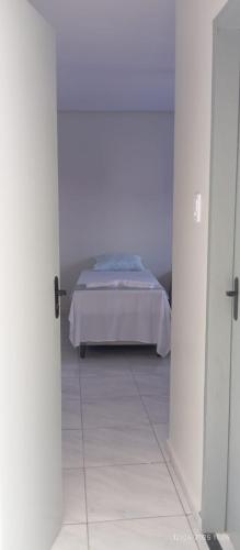 a bedroom with a bed in a white room at A M Hotel in São Luís