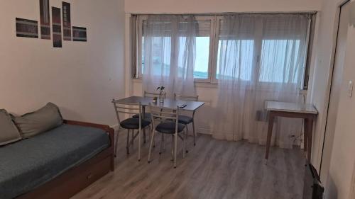 a bedroom with a table and a bed and a window at Depto 1 ambiente in Mar del Plata