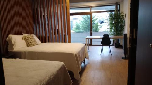 a room with two beds and a table and a window at Oak 2B Loft Ejecutivo en zona 10 in La Aurora