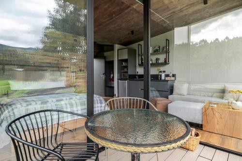 a room with a glass table and chairs on a patio at Las Cabañas by PMJ in Cayambe