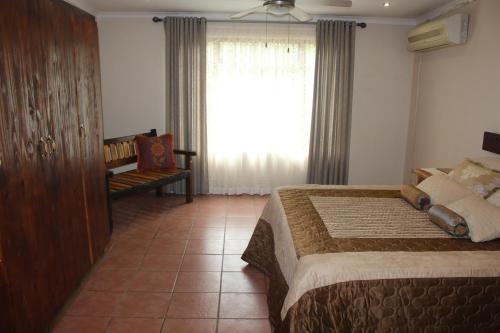 a bedroom with a large bed and a window at Charming Self Catering Apartment in Phalaborwa