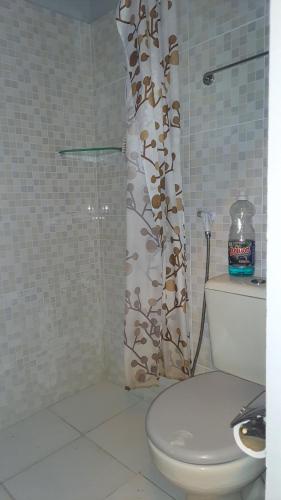 a bathroom with a toilet and a shower curtain at Yamara's somente mulheres in Manaus