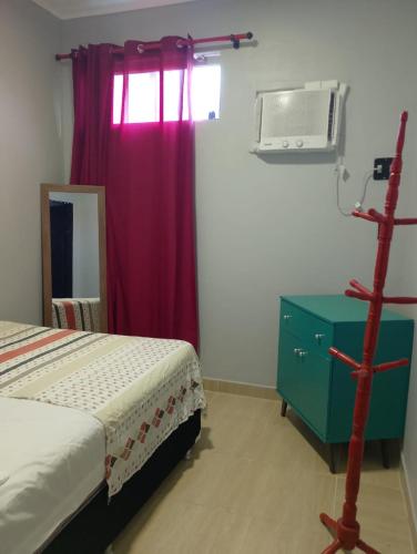 a bedroom with a bed and a dresser and a window at Yamara's somente mulheres in Manaus