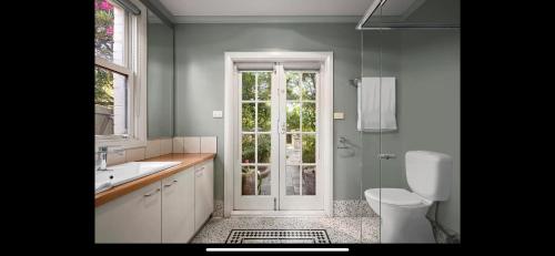 Cozy Beachside 5BR Home with Pool & Rumpus & King beds في ملبورن: حمام مع مرحاض ومغسلة ودش