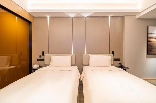two beds in a hotel room with two bedsvisor at Atour Hotel Shenzhen Luohu Vientiane City in Shenzhen