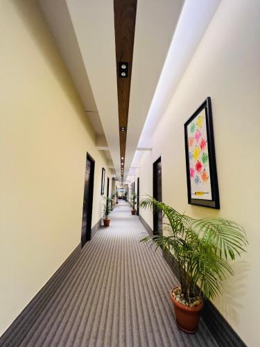 a corridor of an office building with potted plants at Hotel Taj Metro in Maulvi Bāzār
