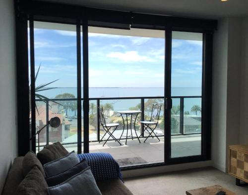 a living room with a view of the ocean at MIRAMAR APARTMENTS 2 Bedroom Apartment with Bay Views on the Geelong Waterfront - 0504 in Geelong