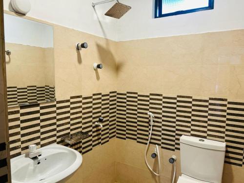 a bathroom with a sink and a toilet at Aura Home Stay in Batticaloa