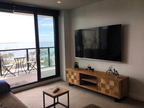 a living room with a flat screen tv on the wall at MIRAMAR APARTMENTS 2 Bedroom Apartment with Bay Views on the Geelong Waterfront - 0504 in Geelong