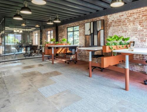 an office with tables and chairs and a brick wall at Luxury Apartment in Bricktown Riverwalk in Oklahoma City