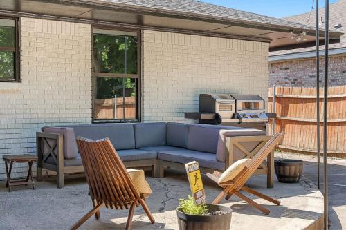 a patio with a blue couch and two chairs at Play & Stay Dallas Home w Gym Gameroom WiFi in Dallas