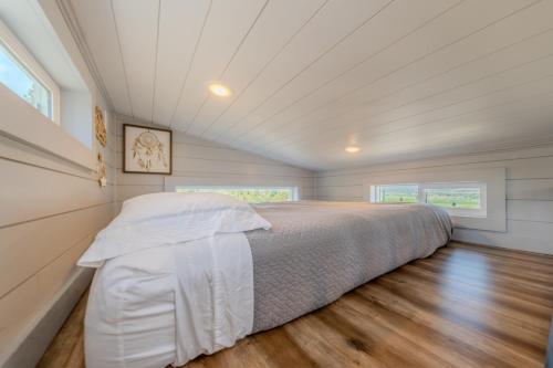 a bedroom with a bed and a wooden floor at Hilltop Tiny Home in Panguitch