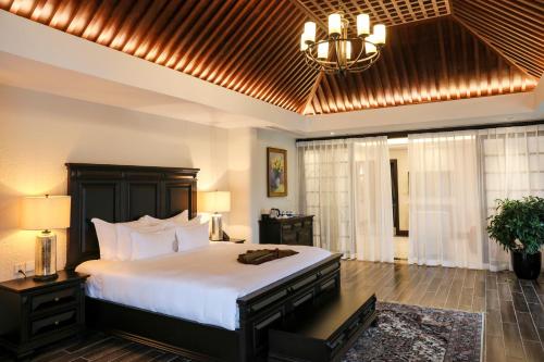 a bedroom with a large bed and a chandelier at Venus Hotel Tam Đảo in Tam Ðảo