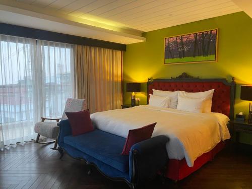 a hotel room with a large bed and a chair at Venus Hotel Tam Đảo in Tam Ðảo