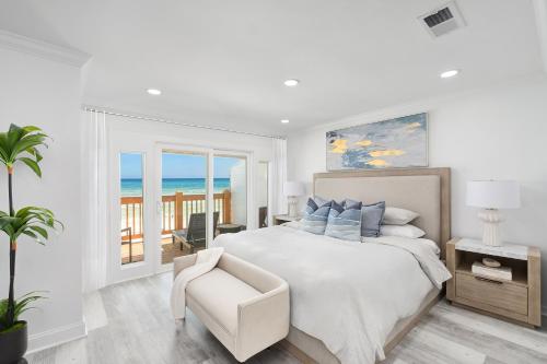 una camera da letto bianca con un letto grande e una sedia di Beachfront Luxury House a Destin