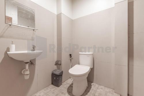 バンドンにあるHotel Ersada Bragaのトイレと洗面台を備えた白いバスルーム