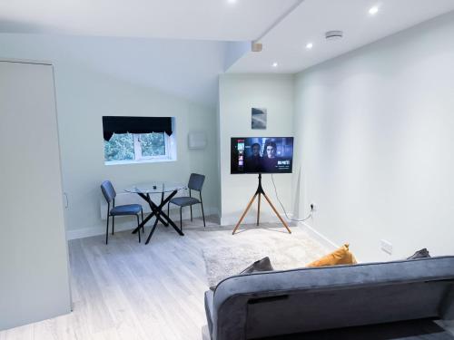 a living room with a couch and a tv and a table at The Octavius Apartment - Huntingdon Town Centre - Designed for Contractors & Professionals - Free WiFi - Smart TV - Fully Equipped Kitchen - Ideal for Long Work Stays in Huntingdon