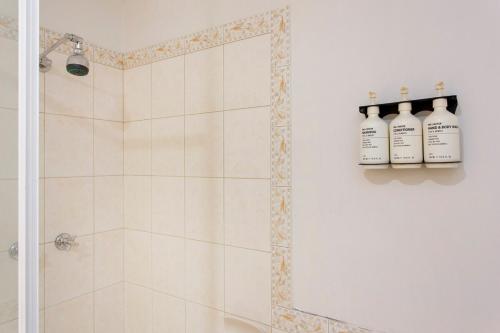a bathroom with a shower with three bottles of soap at Perth Central CBD convenience! in Perth