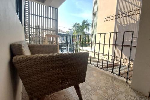 a rattan chair sitting on a balcony with a view at Sukhum Suvarnabhumi Airport Guest House in Ban Klong Plad Kriang