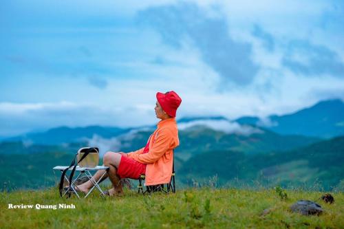 a man sitting in a chair on top of a mountain at Ha Long Essence Boutique Hotel in Ha Long
