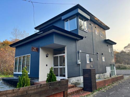 a blue house with a blue at ヴィラYukara緑屋 in Nanae