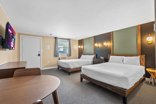 a hotel room with two beds and a table at Inn 32 in North Woodstock