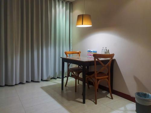 a dining room table with two chairs and a lamp at P.K. Garden Home in Bangkok
