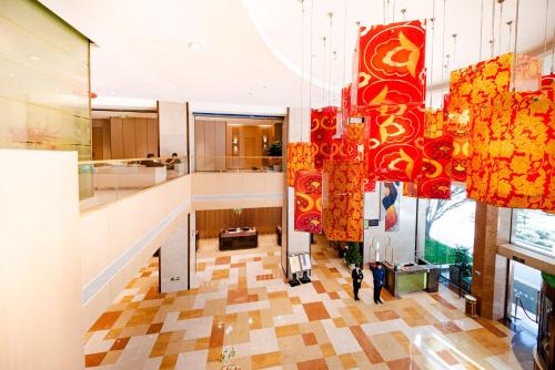 a lobby with red and orange chandeliers in a building at Holiday Inn Xiaoshan by IHG in Hangzhou