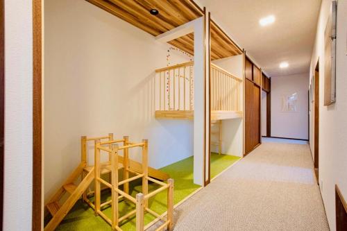 Un pasillo con escalera en una casa. en マイグレ天, en Ito